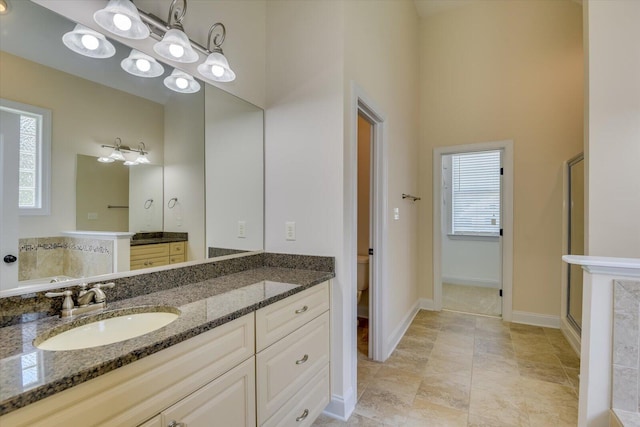 bathroom with vanity, a shower with shower door, and toilet