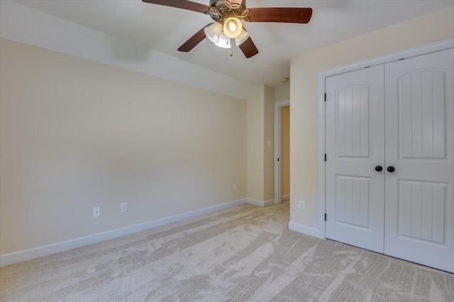 unfurnished bedroom with light carpet, a closet, and ceiling fan