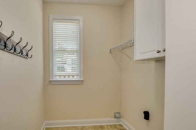 clothes washing area featuring cabinets and a healthy amount of sunlight