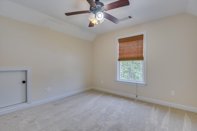 carpeted spare room featuring ceiling fan and vaulted ceiling