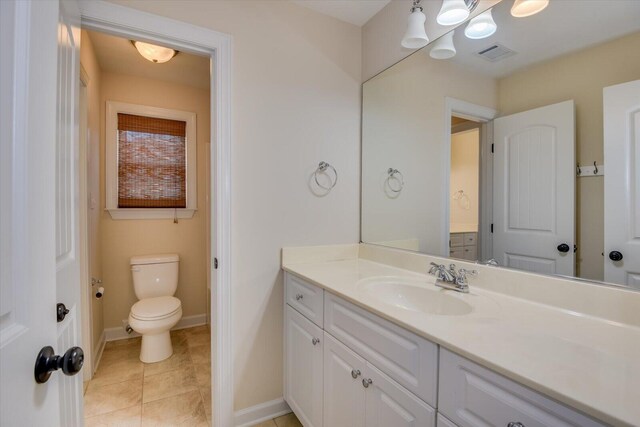 bathroom featuring tile patterned flooring, vanity, and toilet