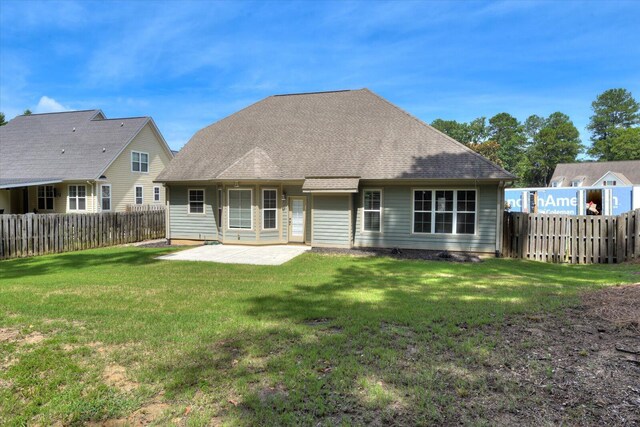 rear view of house with a yard and a patio