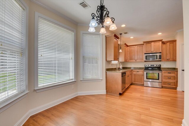 kitchen with ornamental molding, stainless steel appliances, hanging light fixtures, and a chandelier