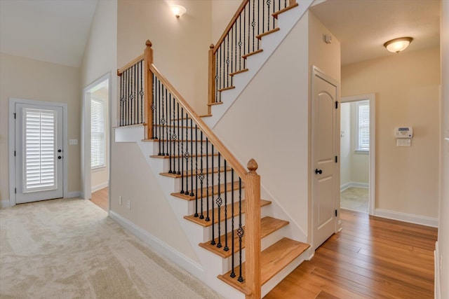 stairway with hardwood / wood-style flooring and lofted ceiling