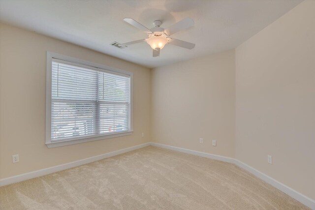 carpeted spare room featuring ceiling fan