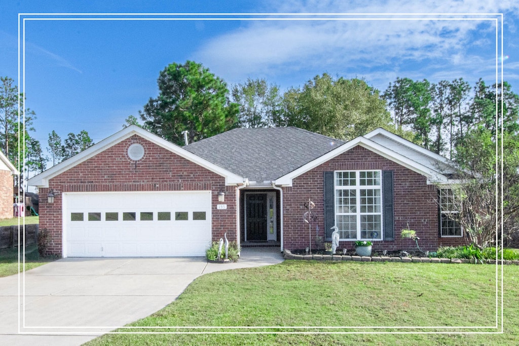 ranch-style home with a garage and a front lawn