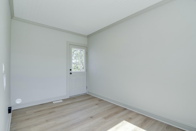 empty room featuring crown molding and light hardwood / wood-style flooring