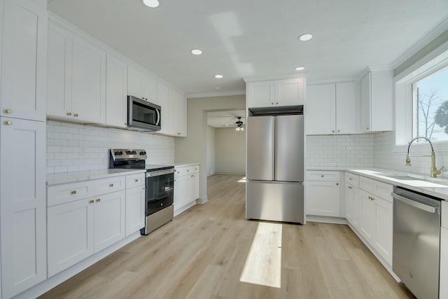 kitchen featuring appliances with stainless steel finishes, sink, and white cabinets