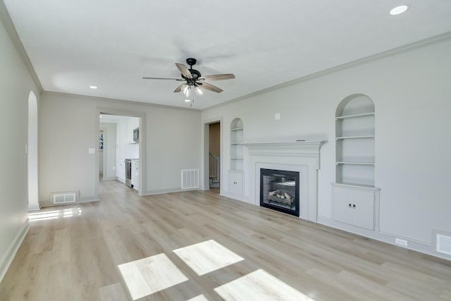 unfurnished living room featuring built in features, ornamental molding, light hardwood / wood-style floors, and ceiling fan