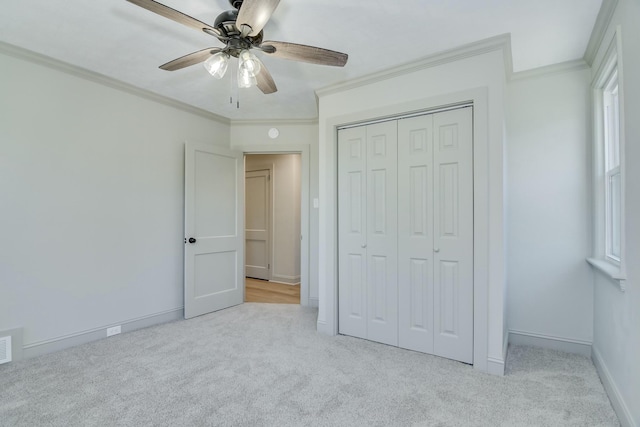 unfurnished bedroom with crown molding, light colored carpet, and a closet