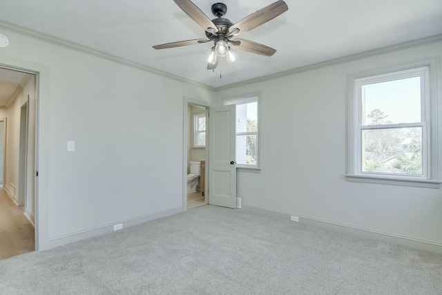 spare room featuring light colored carpet, ornamental molding, and ceiling fan