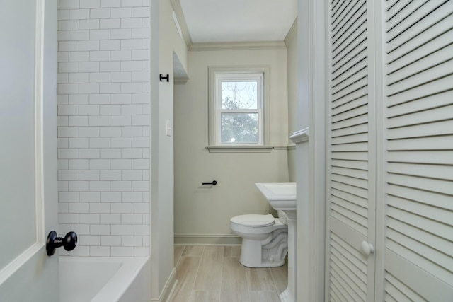 bathroom with ornamental molding and toilet