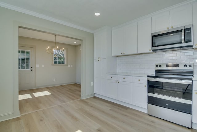 kitchen with appliances with stainless steel finishes, white cabinets, backsplash, and light hardwood / wood-style floors