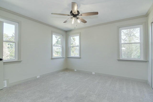 carpeted empty room featuring crown molding, a healthy amount of sunlight, and ceiling fan