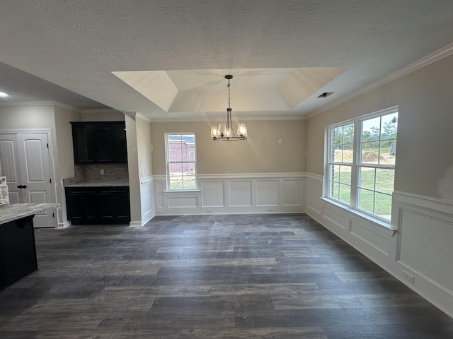 unfurnished dining area with a tray ceiling, dark hardwood / wood-style flooring, and an inviting chandelier