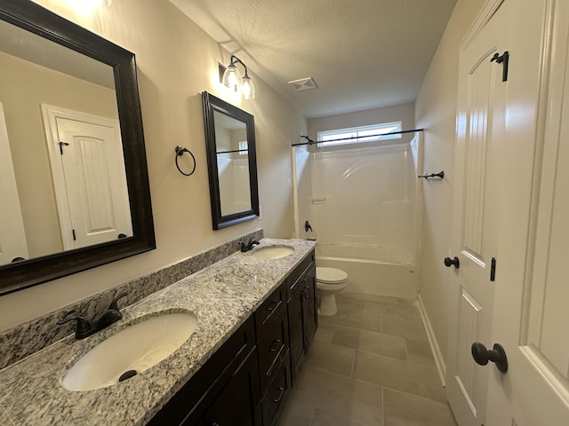 full bathroom featuring tile patterned floors, shower / bathing tub combination, a textured ceiling, toilet, and vanity