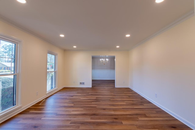 spare room with dark wood-style floors, crown molding, recessed lighting, and an inviting chandelier