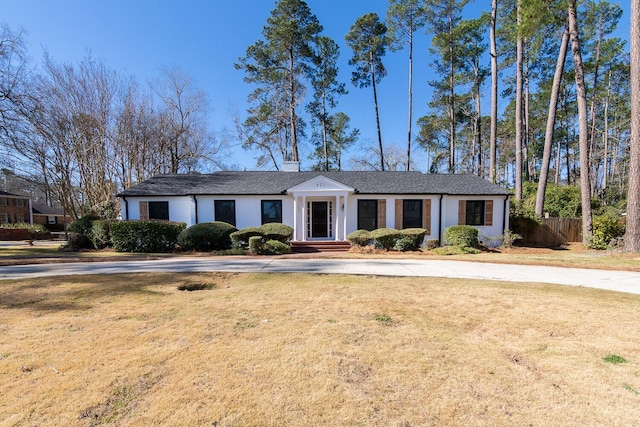 view of front facade with a front yard, fence, and stucco siding