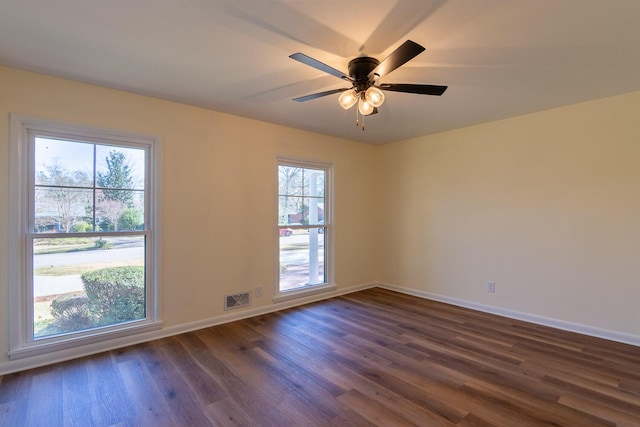 unfurnished room featuring dark wood-type flooring, visible vents, ceiling fan, and baseboards