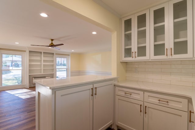 kitchen with a peninsula, ornamental molding, and white cabinets