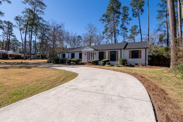 view of front of home with driveway, a front lawn, and fence