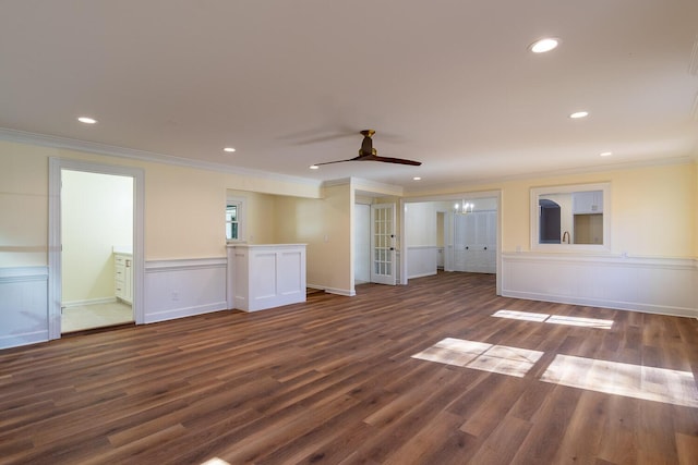 spare room featuring crown molding, ceiling fan with notable chandelier, dark wood-type flooring, and recessed lighting