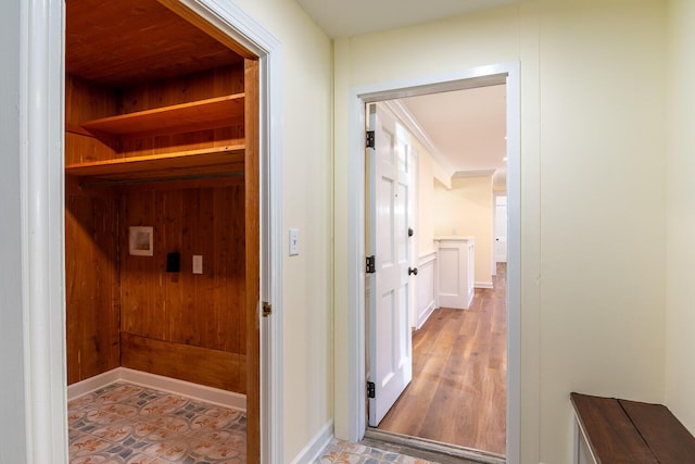 corridor with wood finished floors and baseboards