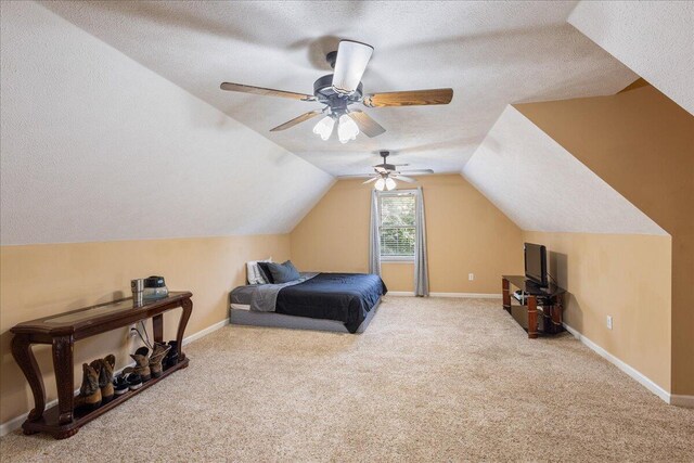 bedroom featuring a textured ceiling, ceiling fan, light carpet, and vaulted ceiling