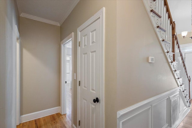 hallway featuring light hardwood / wood-style flooring and crown molding