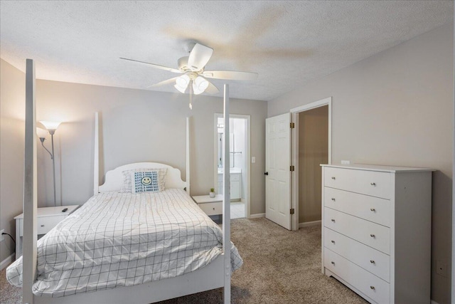 bedroom with connected bathroom, ceiling fan, light colored carpet, and a textured ceiling