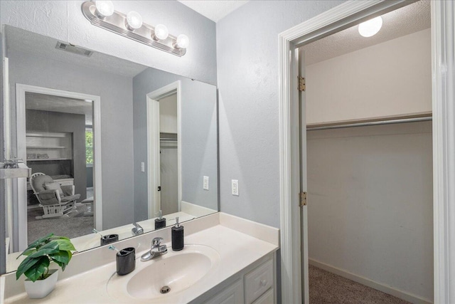 bathroom featuring a textured ceiling and vanity