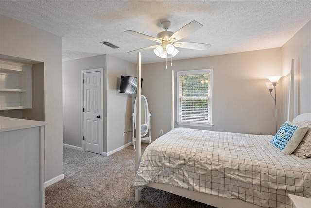 bedroom featuring a textured ceiling, ceiling fan, and light carpet