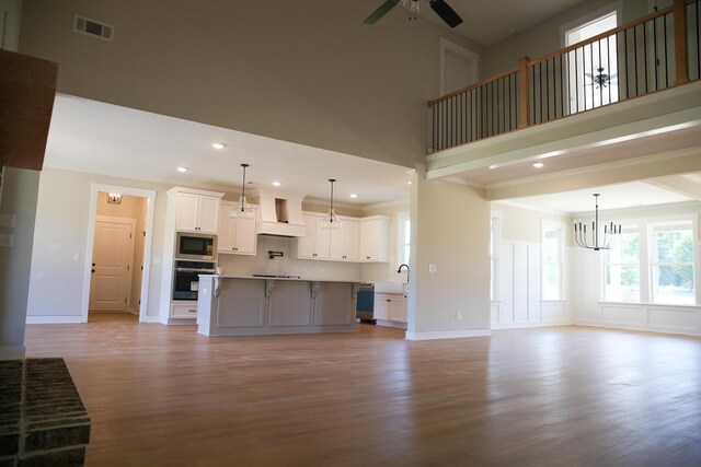 3540 Mistletoe Rd, Appling, GA 30802 - unfurnished living room with recessed lighting, light wood finished floors, visible vents, ceiling fan with notable chandelier, and a towering ceiling