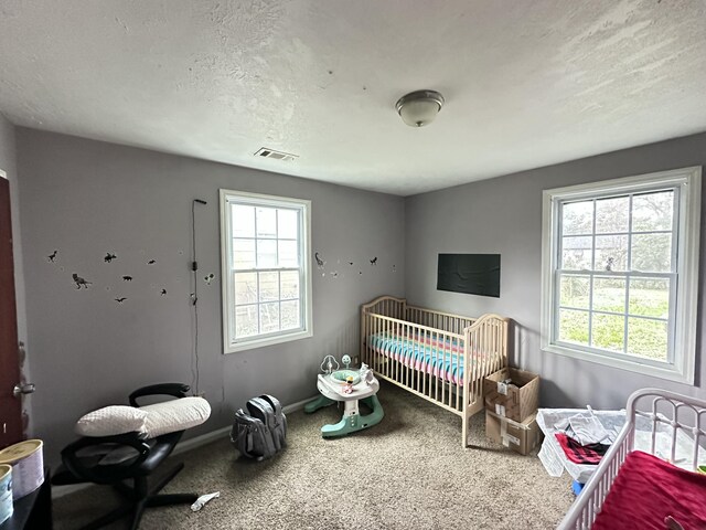 bedroom featuring a crib and a textured ceiling