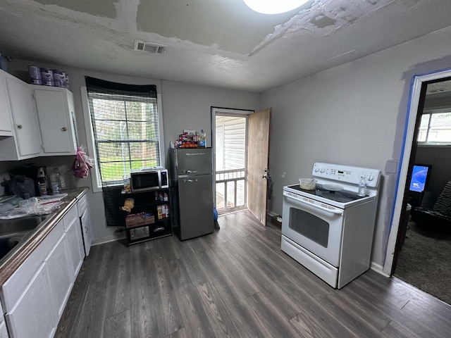 kitchen with a wealth of natural light, white cabinetry, dark hardwood / wood-style flooring, and appliances with stainless steel finishes