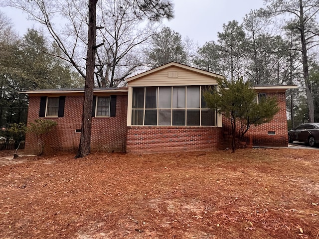 rear view of property featuring a sunroom