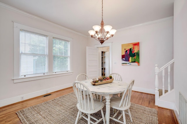 1534 Whitney St, Augusta, GA 30904 - dining room with ornamental molding, a chandelier, light wood finished floors, baseboards, and stairs
