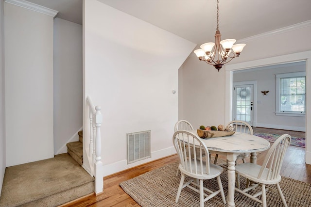 1534 Whitney St, Augusta, GA 30904 - dining area featuring a chandelier, light wood-style flooring, ornamental molding, stairway, and baseboards