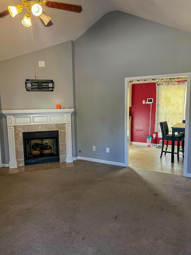 living room featuring a tiled fireplace, ceiling fan, light carpet, and lofted ceiling