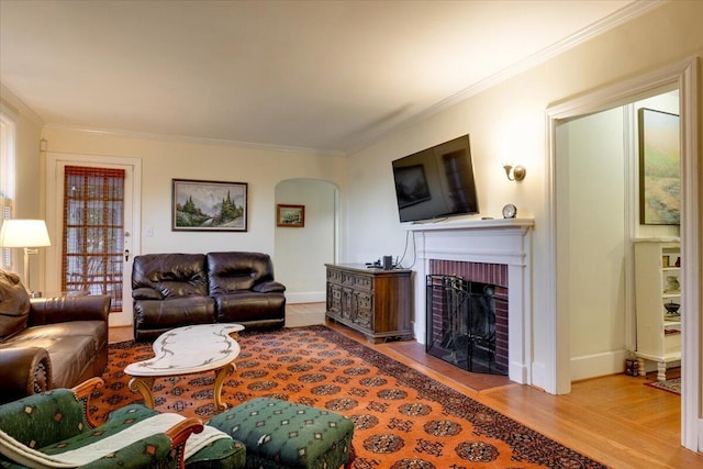 living room featuring a fireplace, light hardwood / wood-style floors, and ornamental molding