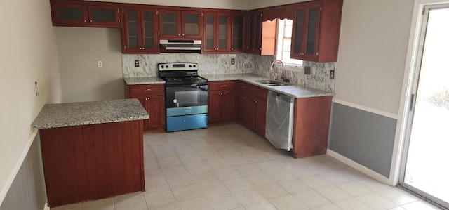 kitchen featuring light stone countertops, appliances with stainless steel finishes, decorative backsplash, and sink