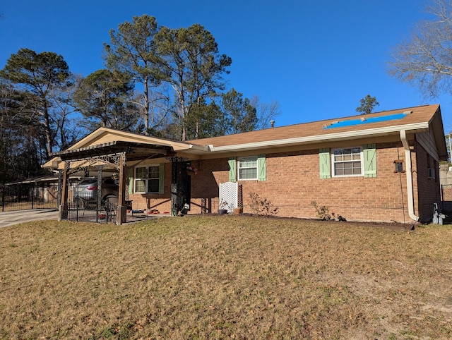 ranch-style house featuring driveway, a front lawn, an attached carport, and brick siding