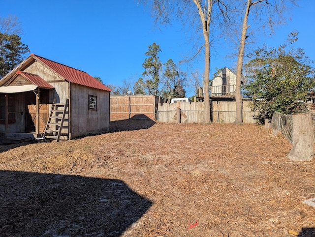 view of yard with fence and an outbuilding