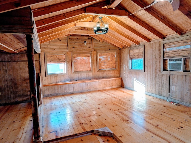 interior space with lofted ceiling, hardwood / wood-style floors, wood walls, and cooling unit