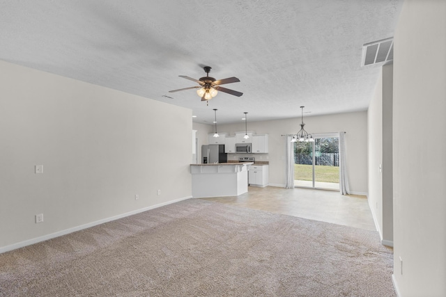 unfurnished living room featuring visible vents, baseboards, light colored carpet, a textured ceiling, and ceiling fan with notable chandelier