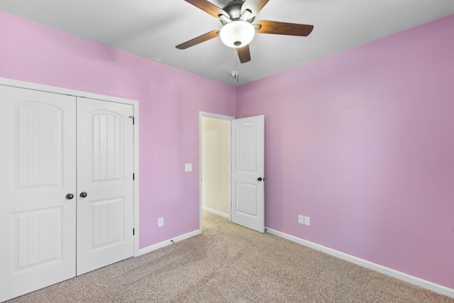 unfurnished bedroom featuring carpet, baseboards, and a closet