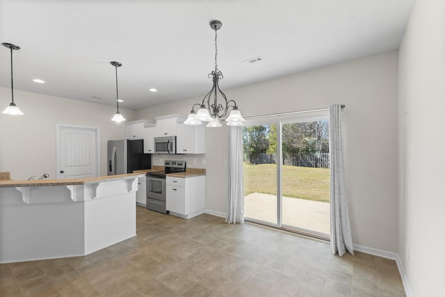 kitchen with visible vents, hanging light fixtures, appliances with stainless steel finishes, white cabinets, and a kitchen bar