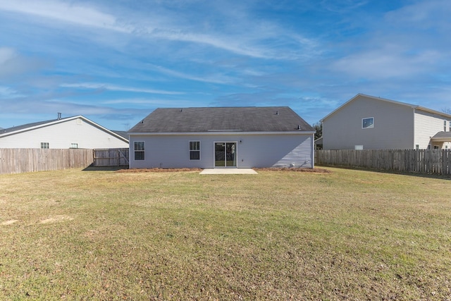 rear view of property featuring a patio, a lawn, and a fenced backyard