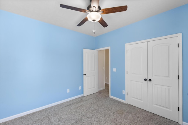 unfurnished bedroom with carpet floors, ceiling fan, baseboards, and a closet