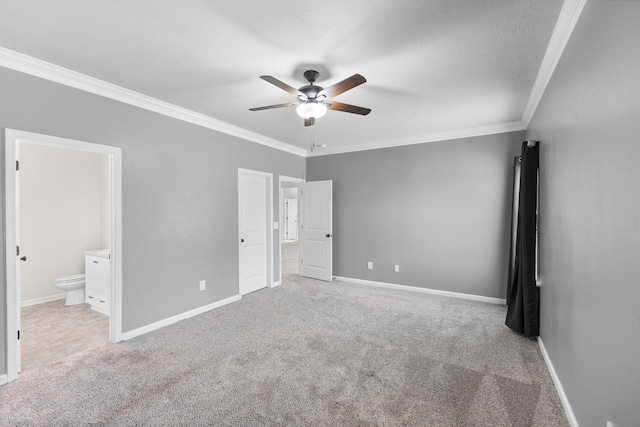 unfurnished bedroom featuring carpet, crown molding, and baseboards